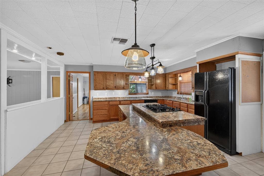 9468 Ranch Lane, Shreveport, LA 71106 Kitchen featuring a central island with a built-in cooktop, extensive counter space, wood cabinetry, and tiled flooring