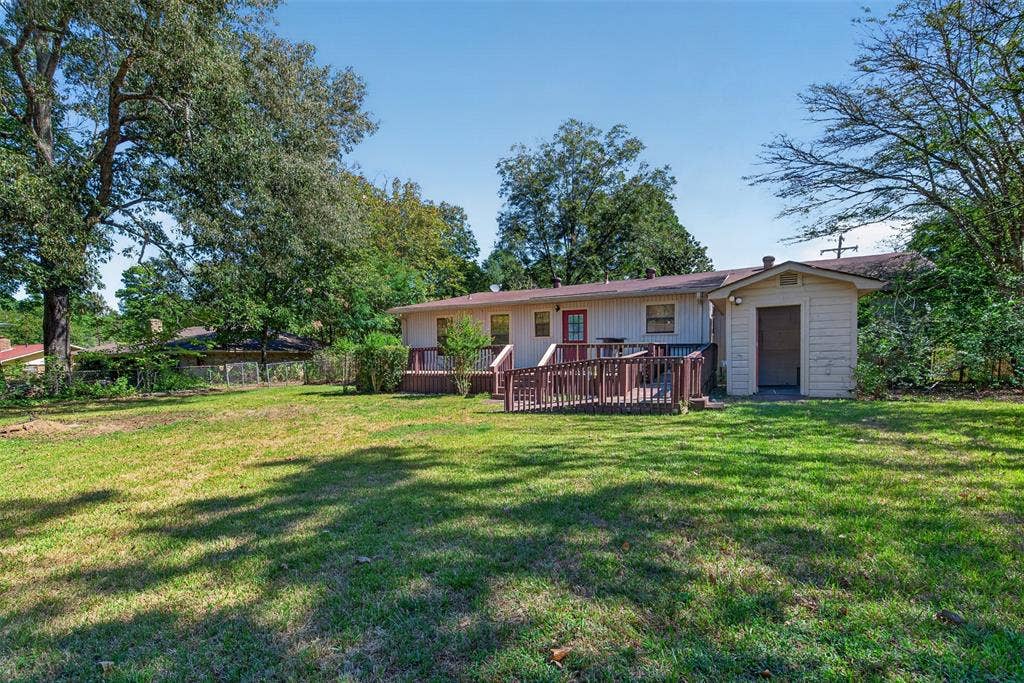 9468 Ranch Lane, Shreveport, LA 71106 Expansive rear yard with a manicured lawn, established landscaping, and mature trees