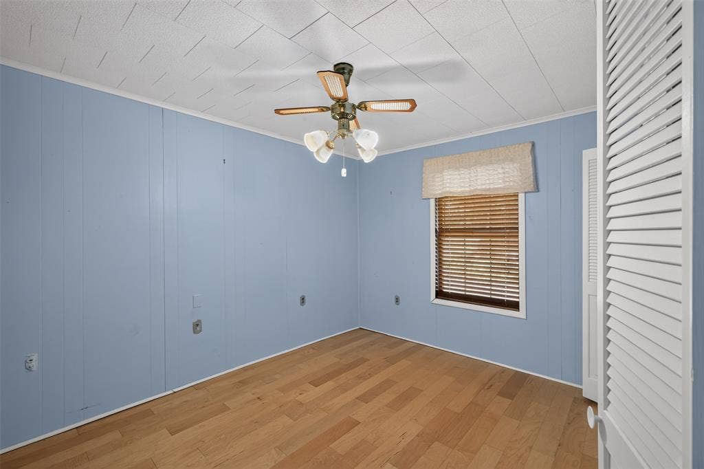 9468 Ranch Lane, Shreveport, LA 71106 Wood-finish flooring, paneled walls, and a ceiling fan with integrated lighting
