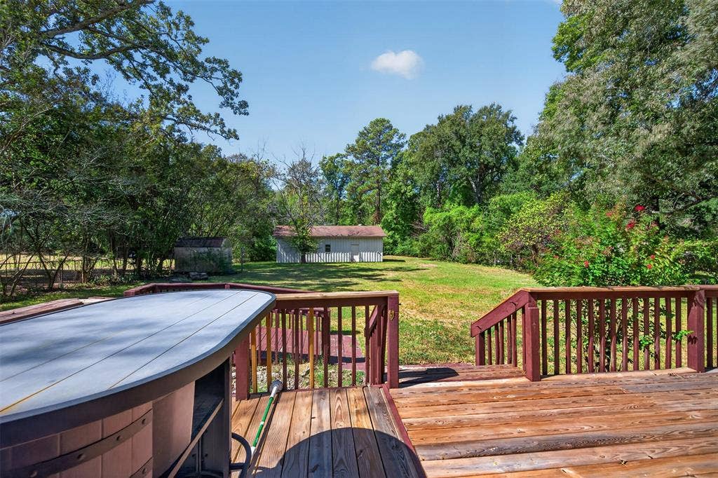 9468 Ranch Lane, Shreveport, LA 71106 Hardwood deck with railings, integrated hot tub, and a spacious grassy yard