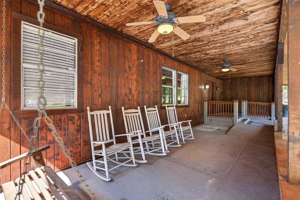 9468 Ranch Lane, Shreveport, LA 71106 Expansive wood-paneled porch featuring a wood-plank ceiling, two built-in ceiling fans, and a concrete floor