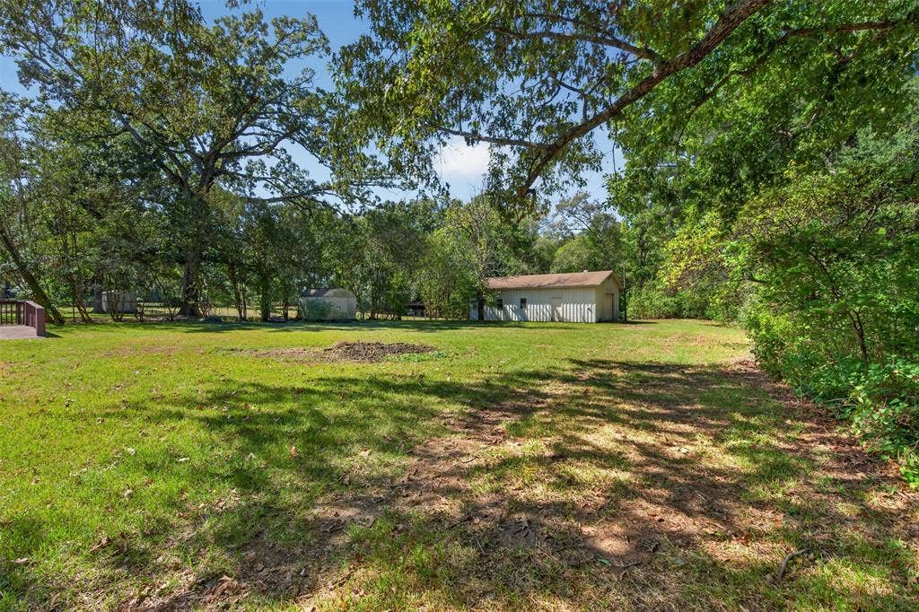 9468 Ranch Lane, Shreveport, LA 71106 Expansive green lawn with mature trees and a detached structure