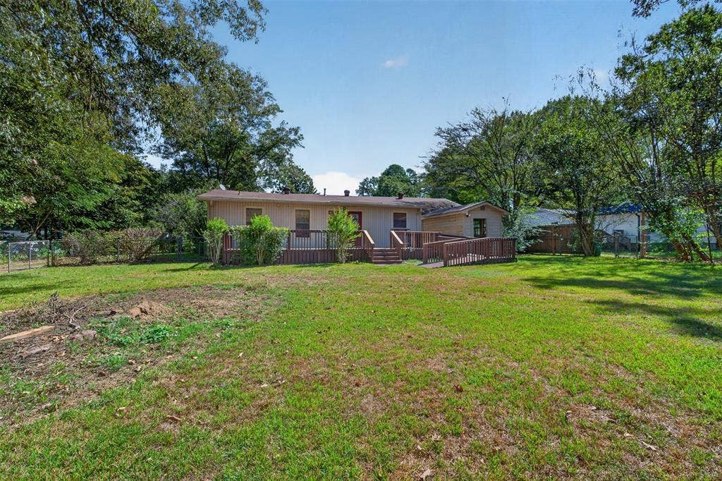 9468 Ranch Lane, Shreveport, LA 71106 Expansive green lawn, wood deck, and ramp access