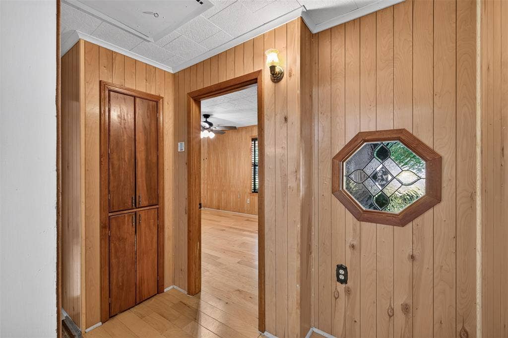 9468 Ranch Lane, Shreveport, LA 71106 Wood-paneled walls featuring an octagonal stained-glass window and wood-finish flooring