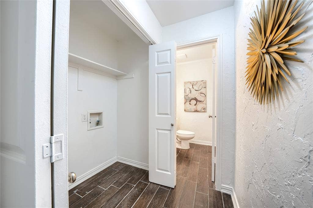 1600 Brentwood Drive, Irving, TX 75061 Laundry area with a built-in shelf, wood-finish flooring, and a bifold door