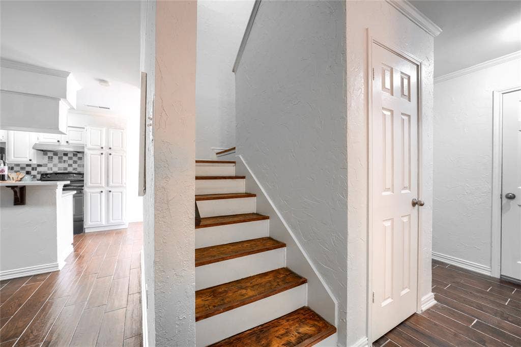 1600 Brentwood Drive, Irving, TX 75061 Wood-finish flooring throughout, white paneled doors, and a staircase with wood treads and white risers