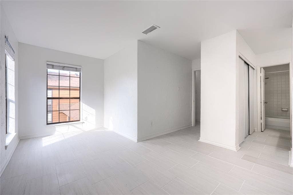 1600 Brentwood Drive, Irving, TX 75061 White tile flooring, multiple windows, and a sliding door closet