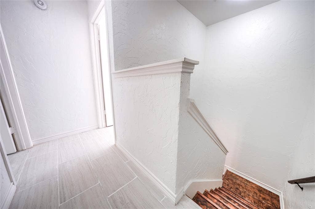 1600 Brentwood Drive, Irving, TX 75061 Hallway with light-toned rectangular tile flooring, white walls with textured finish, and white trim