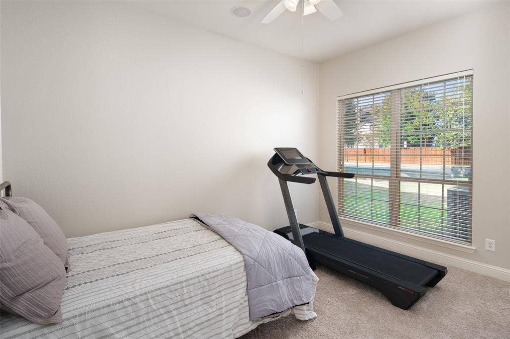 Carpeted room featuring a ceiling fan, a large window with blinds, and recessed lighting