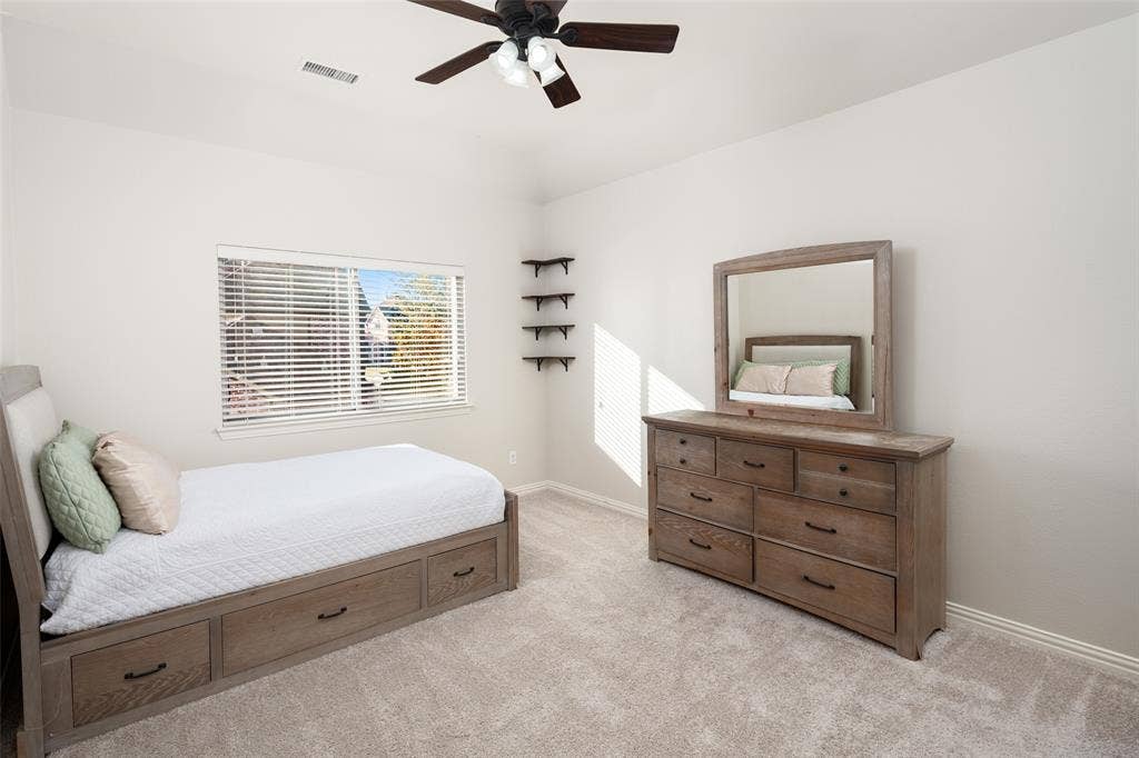 Recessed window with blinds, ceiling fan with integrated lighting, and neutral carpeting