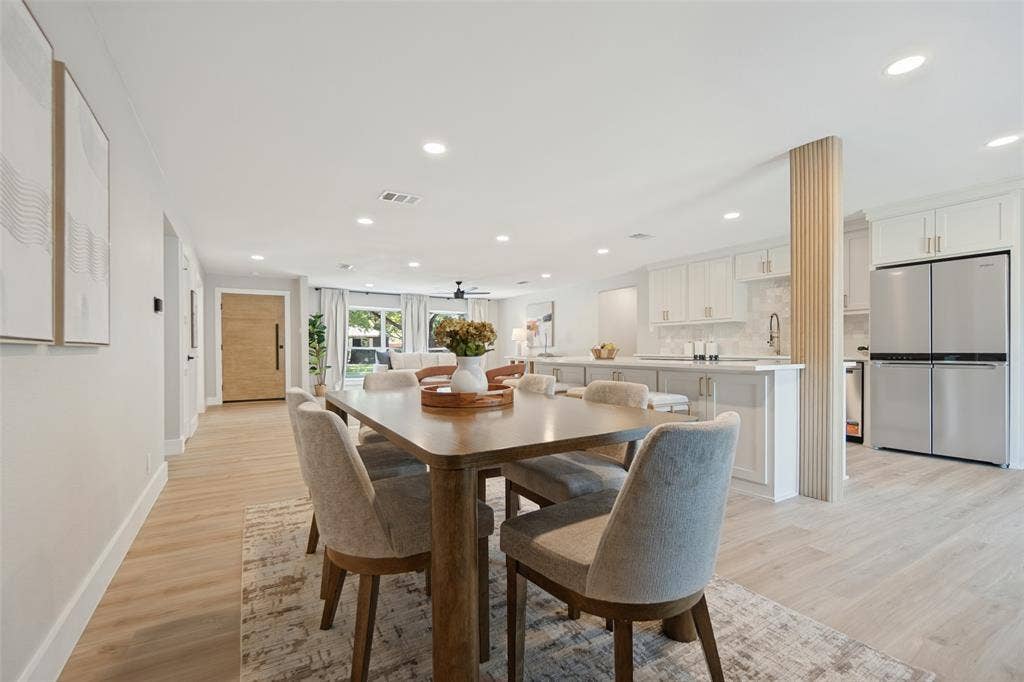 3129 Flowerdale Lane, Dallas, TX 75229 Open-concept living space with light wood-finish flooring, recessed lighting, white shaker cabinets, and stainless steel appliances