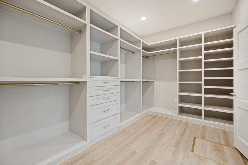 3129 Flowerdale Lane, Dallas, TX 75229 Built-in custom cabinetry with shelving, drawer storage, hanging rods, and wood-finish flooring