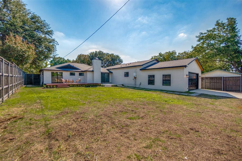 3129 Flowerdale Lane, Dallas, TX 75229 Expansive backyard with a wooden fence, detached covered parking, and a private wooden deck