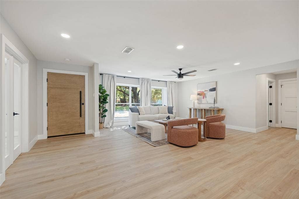 3129 Flowerdale Lane, Dallas, TX 75229 Open-concept living area featuring wood-finish flooring, recessed lighting, a modern ceiling fan, and large windows with white curtains