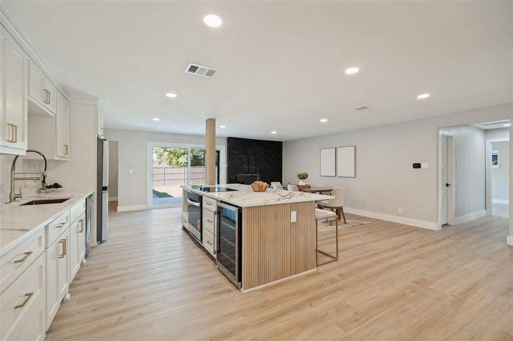 3129 Flowerdale Lane, Dallas, TX 75229 Open-concept living space with light wood-finish flooring, recessed lighting, and white cabinetry