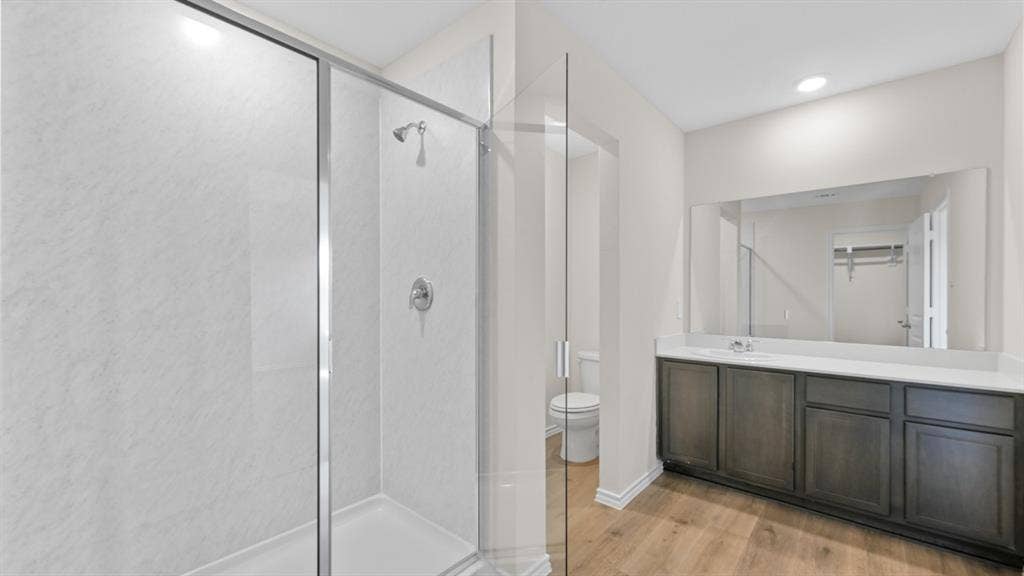5431 Cormorant Grove, Crandall, TX 75114 Modern bathroom featuring a glass-enclosed shower with white paneling and chrome fixtures