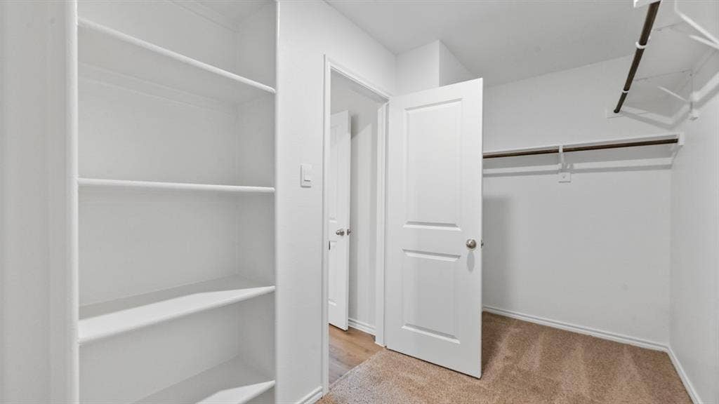 5430 Cormorant Grove, Crandall, TX 75114 Built-in shelving unit providing organized storage, complemented by a separate closet area with hanging rods