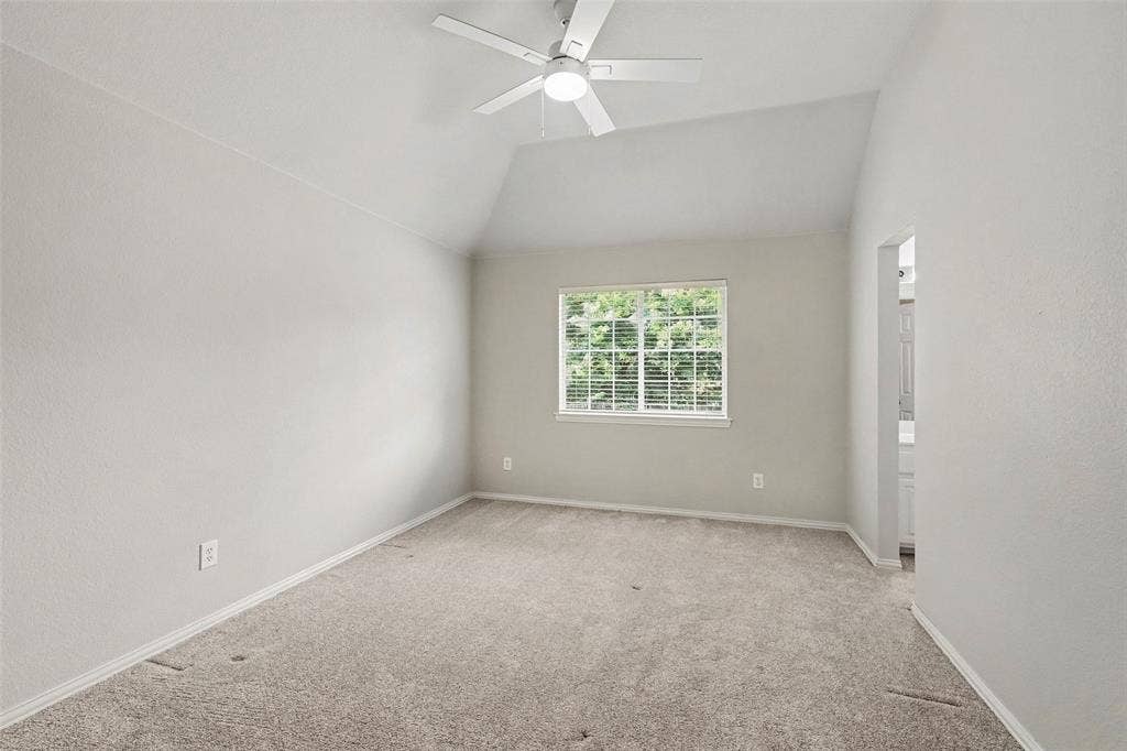 7813 San Isabel Drive, Plano, TX 75025 Vaulted ceiling, ceiling fan, carpet flooring, window with white blinds, and an open doorway