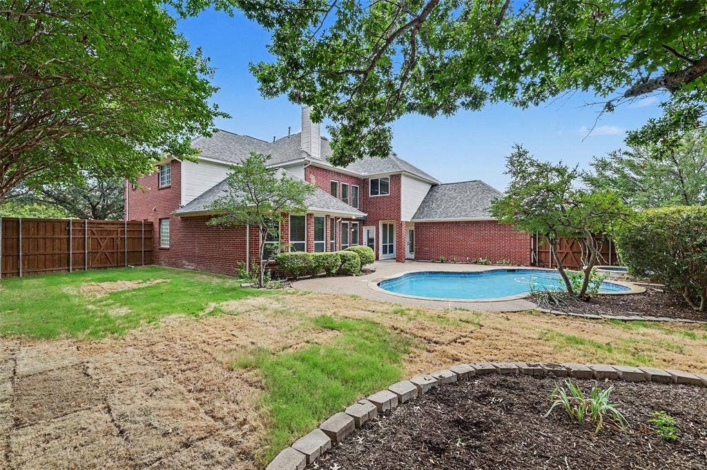 7813 San Isabel Drive, Plano, TX 75025 Brick exterior, built-in swimming pool, integrated spa, mature trees, and a privacy fence
