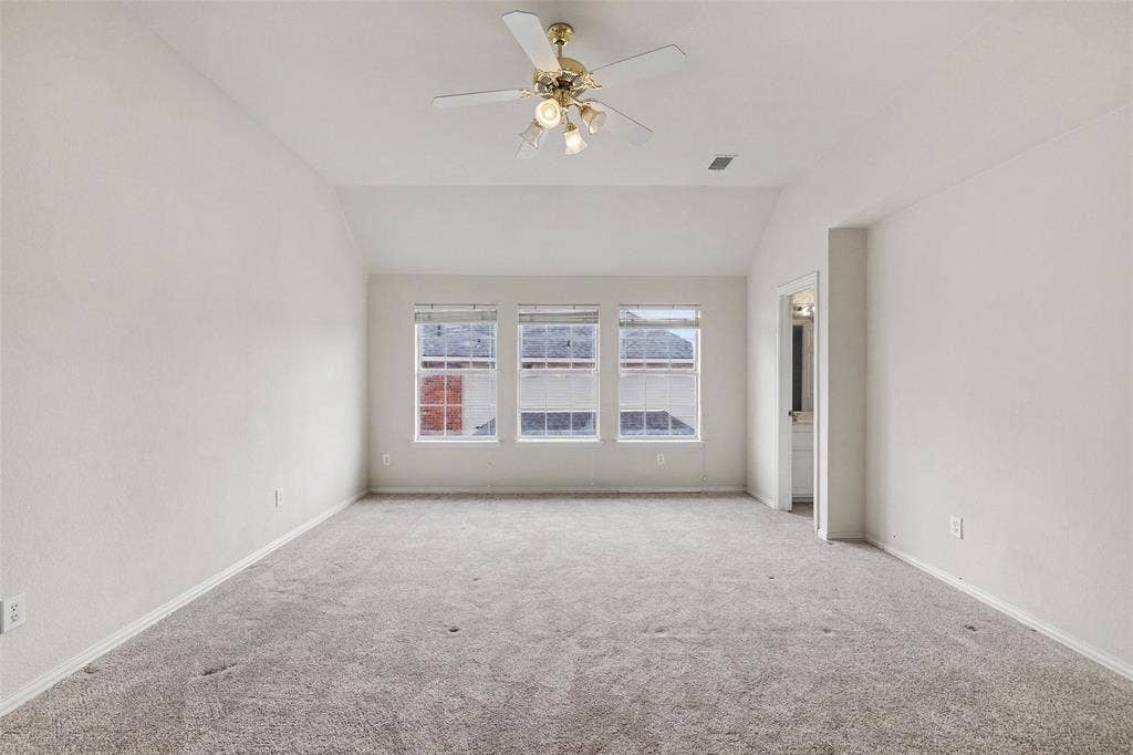 7813 San Isabel Drive, Plano, TX 75025 Vaulted ceiling with a ceiling fan, three windows, and plush carpet flooring