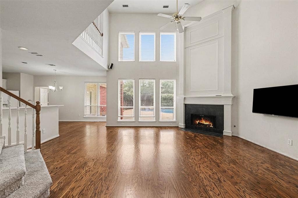 7813 San Isabel Drive, Plano, TX 75025 Soaring two-story great room with cathedral ceiling and ceiling fan, anchored by a gas fireplace with surround