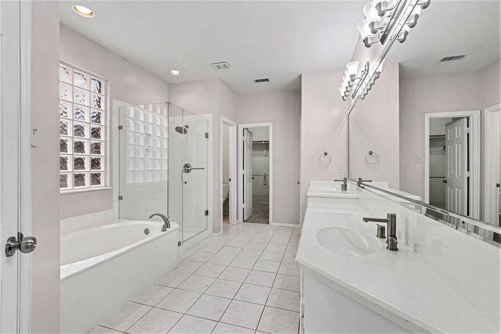 7813 San Isabel Drive, Plano, TX 75025 Spa-inspired primary bathroom featuring dual vanities with white quartz countertops, polished chrome fixtures, and an illuminated mirror