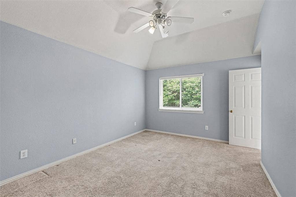 7813 San Isabel Drive, Plano, TX 75025 Room featuring vaulted ceilings, plush carpet flooring, a ceiling fan with integrated lighting, a window with blinds, and a paneled door