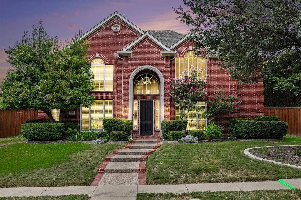 7813 San Isabel Drive, Plano, TX 75025 Red brick exterior with arched windows, mature landscaping, and a stepping stone pathway