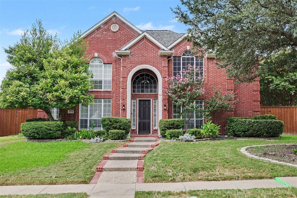 7813 San Isabel Drive, Plano, TX 75025 Red brick exterior with arched entry, complementing arched windows, and a multi-level roofline