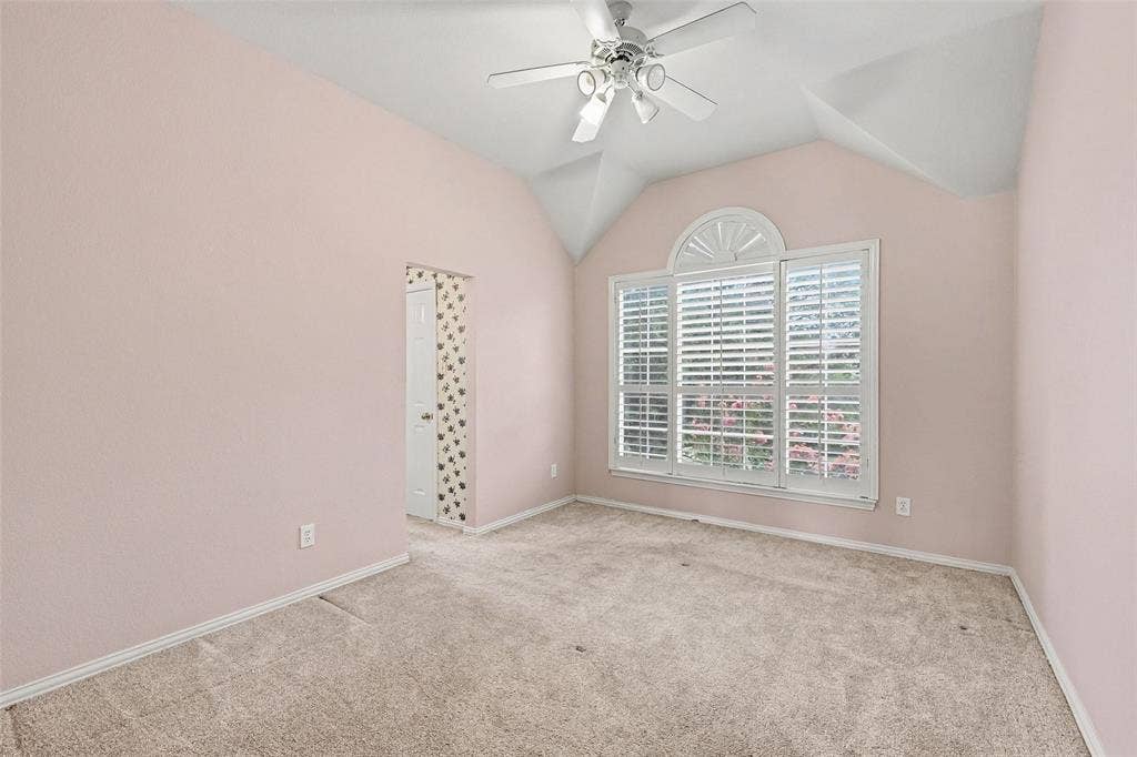 7813 San Isabel Drive, Plano, TX 75025 Vaulted ceiling with an attached ceiling fan, arched window with plantation shutters, carpeted flooring, and a white interior door