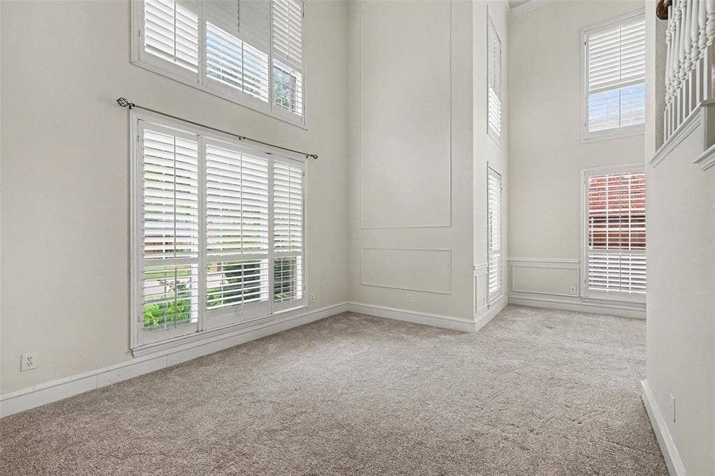 7813 San Isabel Drive, Plano, TX 75025 Two-story ceiling, multiple windows with white plantation shutters, decorative wall molding, and plush carpeting