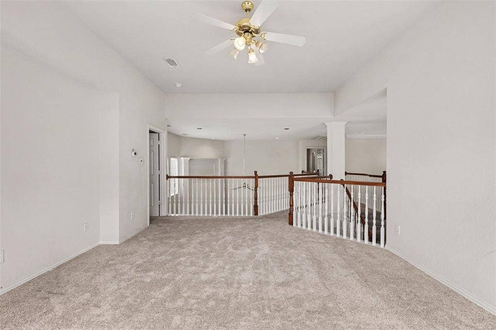 7813 San Isabel Drive, Plano, TX 75025 Carpeted open-concept bonus room featuring a ceiling fan, white balustrade railing with wood-finish top rail, and recessed lighting