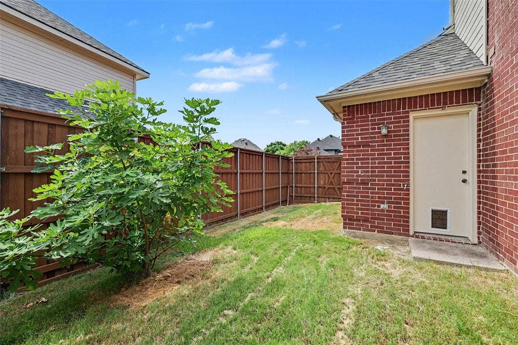 7813 San Isabel Drive, Plano, TX 75025 Brick exterior with a side entry door, enclosed by wood fencing