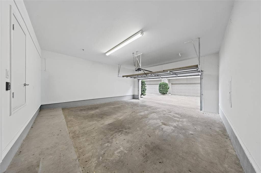 4312 Mckinney Avenue, #4, Dallas, TX 75205 Spacious garage featuring a concrete floor, bright overhead lighting, and an automatic garage door opener mechanism