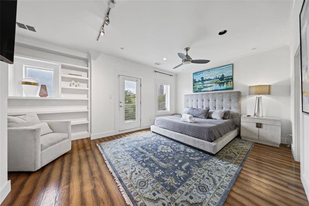 4312 Mckinney Avenue, #4, Dallas, TX 75205 Wood-finish flooring, built-in shelving, white walls, and a ceiling fan with integrated lighting