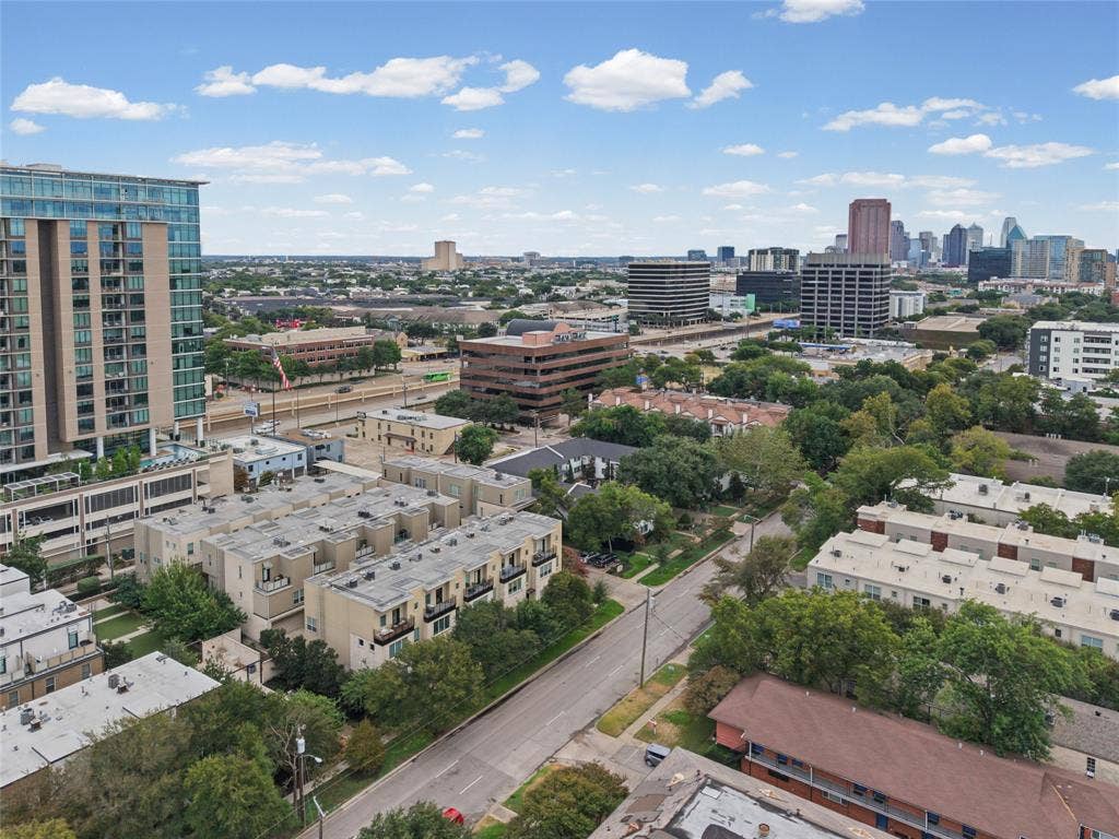 4312 Mckinney Avenue, #4, Dallas, TX 75205 Urban landscape featuring a high-rise building with glass facade, multiple multi-story residential structures, a prominent road network, and extensive tree canopy