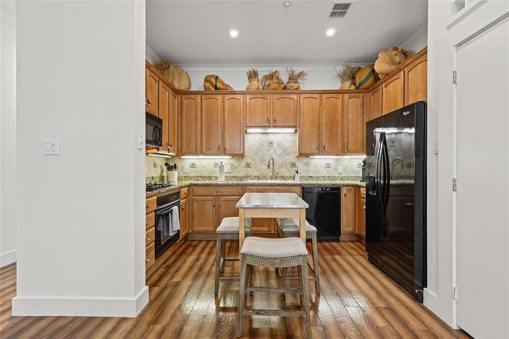 4312 Mckinney Avenue, #4, Dallas, TX 75205 Kitchen featuring wood-finish flooring, recessed lighting, wood cabinetry, stone countertops, and a tiled backsplash