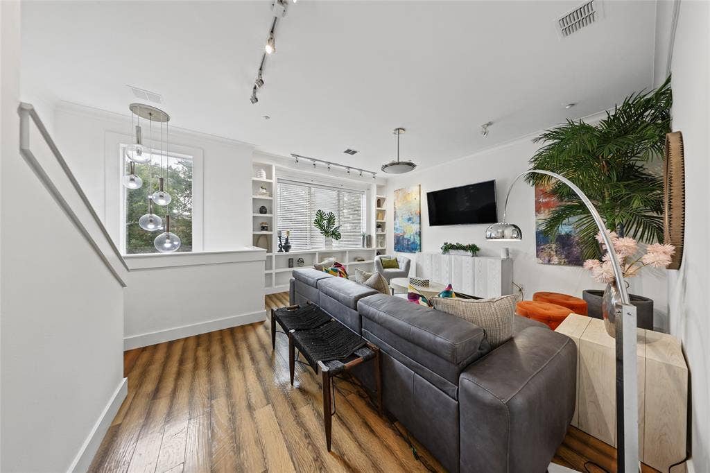 4312 Mckinney Avenue, #4, Dallas, TX 75205 Wood-finish flooring, built-in shelving, white walls, and track lighting