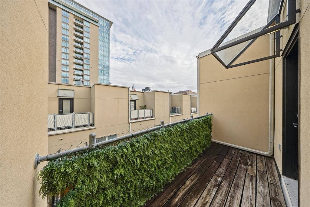 4312 Mckinney Avenue, #4, Dallas, TX 75205 Balcony with wood-finish flooring, a decorative green privacy screen, and a modern glass awning