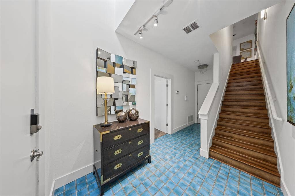 4312 Mckinney Avenue, #4, Dallas, TX 75205 Two-story foyer featuring blue square tile flooring, wood stairs with white risers, white painted walls, and track lighting