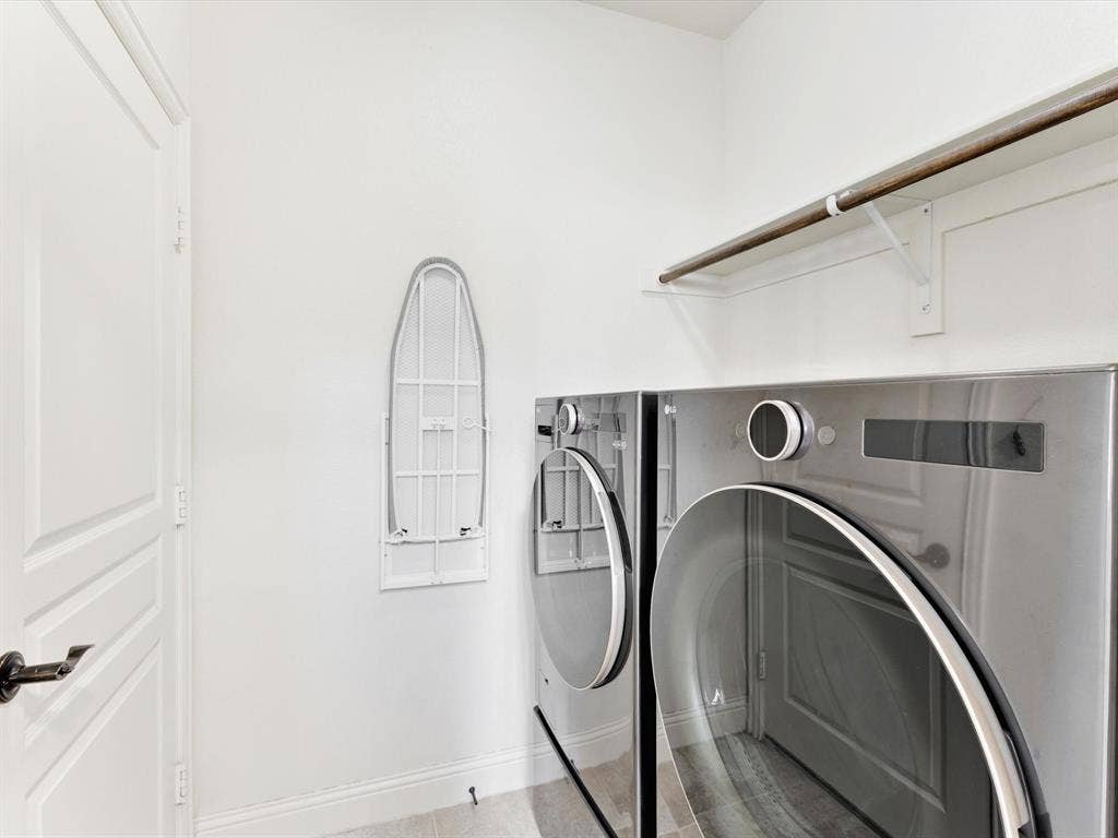 1020 Fallon Drive, McKinney, TX 75071 Dedicated laundry area with modern appliances, integrated shelving, and a wall-mounted ironing board