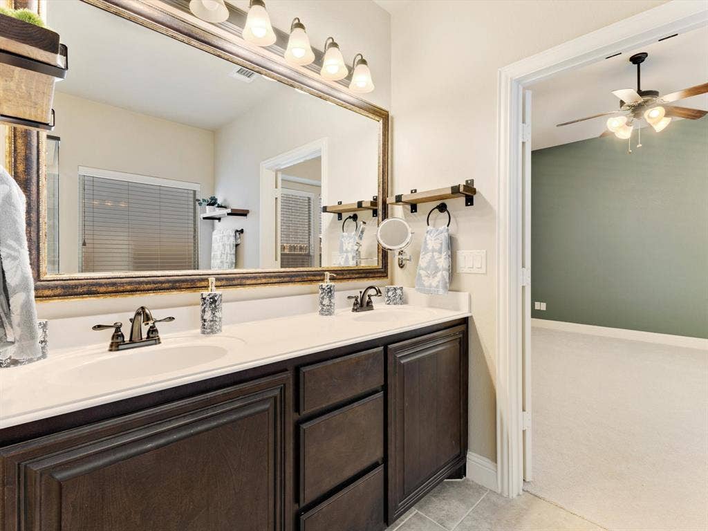1020 Fallon Drive, McKinney, TX 75071 Dual vanity with dark wood-finish cabinetry, integrated sinks, and bronze-finish faucets