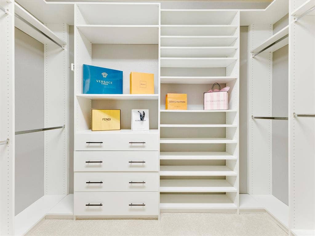 1020 Fallon Drive, McKinney, TX 75071 Custom closet system featuring multiple shelves, hanging rods, and built-in drawers with matte black hardware
