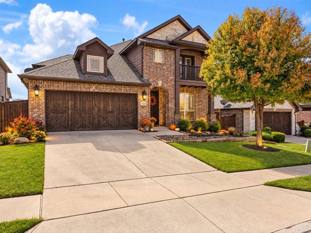 1020 Fallon Drive, McKinney, TX 75071 Brick and stone exterior with dark wood-finish garage doors and trim