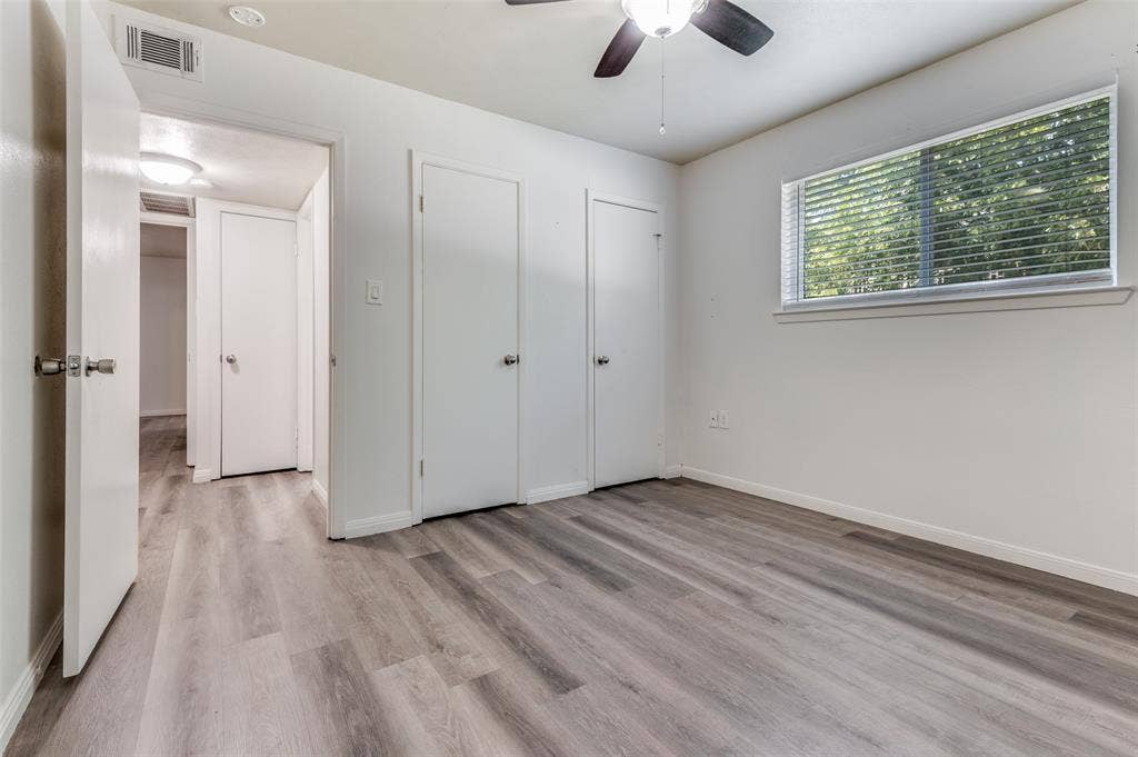 428 N Dallas Avenue, #3, Lancaster, TX 75146 Wood-finish flooring, white painted walls, window with blinds, ceiling fan, and multiple interior doors