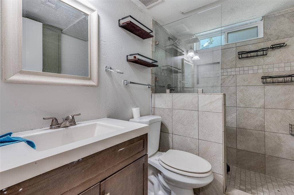 428 N Dallas Avenue, #3, Lancaster, TX 75146 Vanity with integrated sink, framed mirror, and walk-in shower with glass enclosure and tiled walls