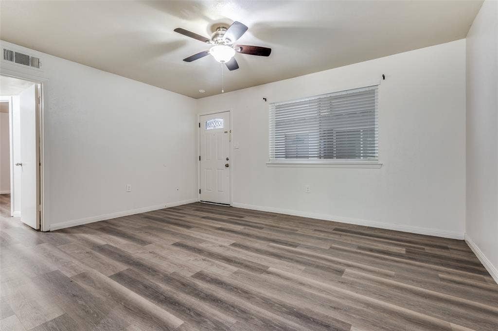 428 N Dallas Avenue, #3, Lancaster, TX 75146 Wood-finish flooring throughout, white walls, ceiling fan with integrated lighting, and a window with blinds