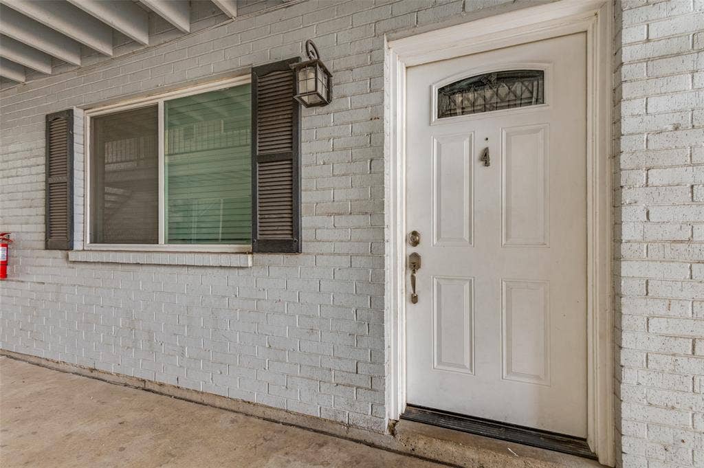 428 N Dallas Avenue, #3, Lancaster, TX 75146 White brick exterior with a paneled entry door, transom window, and brass hardware
