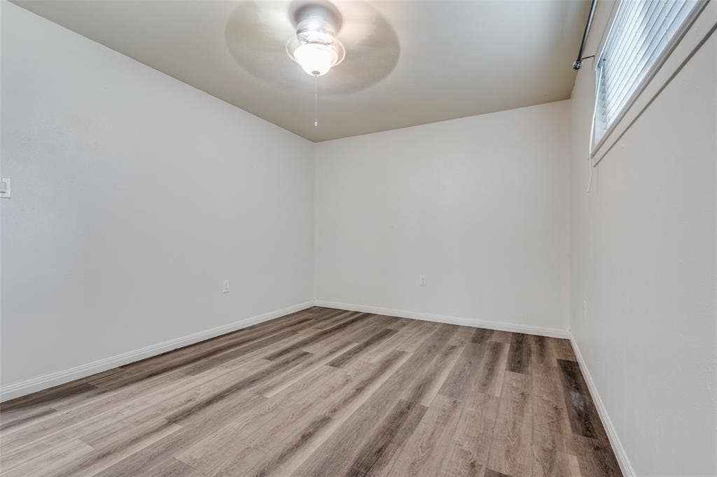 428 N Dallas Avenue, #3, Lancaster, TX 75146 Wood-finish flooring, white walls, ceiling fan with integrated lighting, and window with blinds