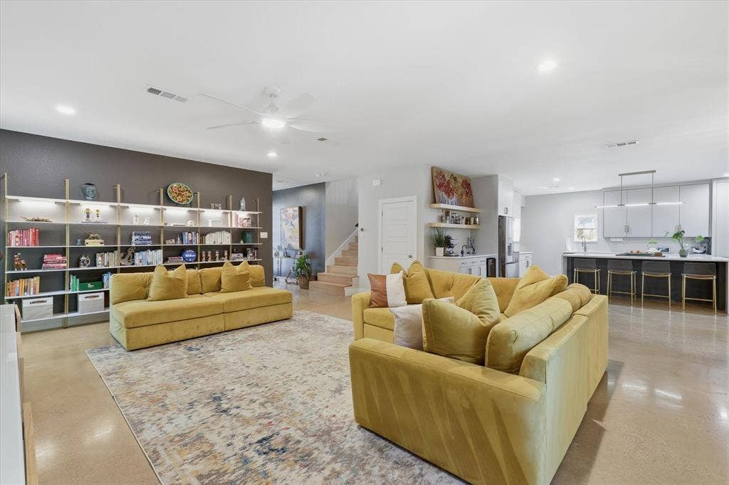 709 Woodbine Avenue, Dallas, TX 75203 Open-concept living area featuring a built-in shelving system with integrated lighting, polished concrete flooring, recessed lighting, and a ceiling fan